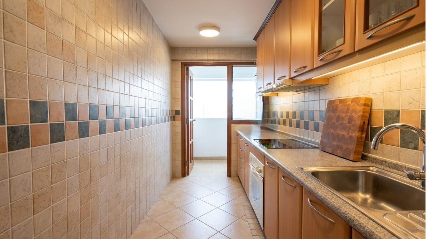 Kitchen with wooden cabinets after PropEdit enhancement — brighter, decluttered, herbs on sill